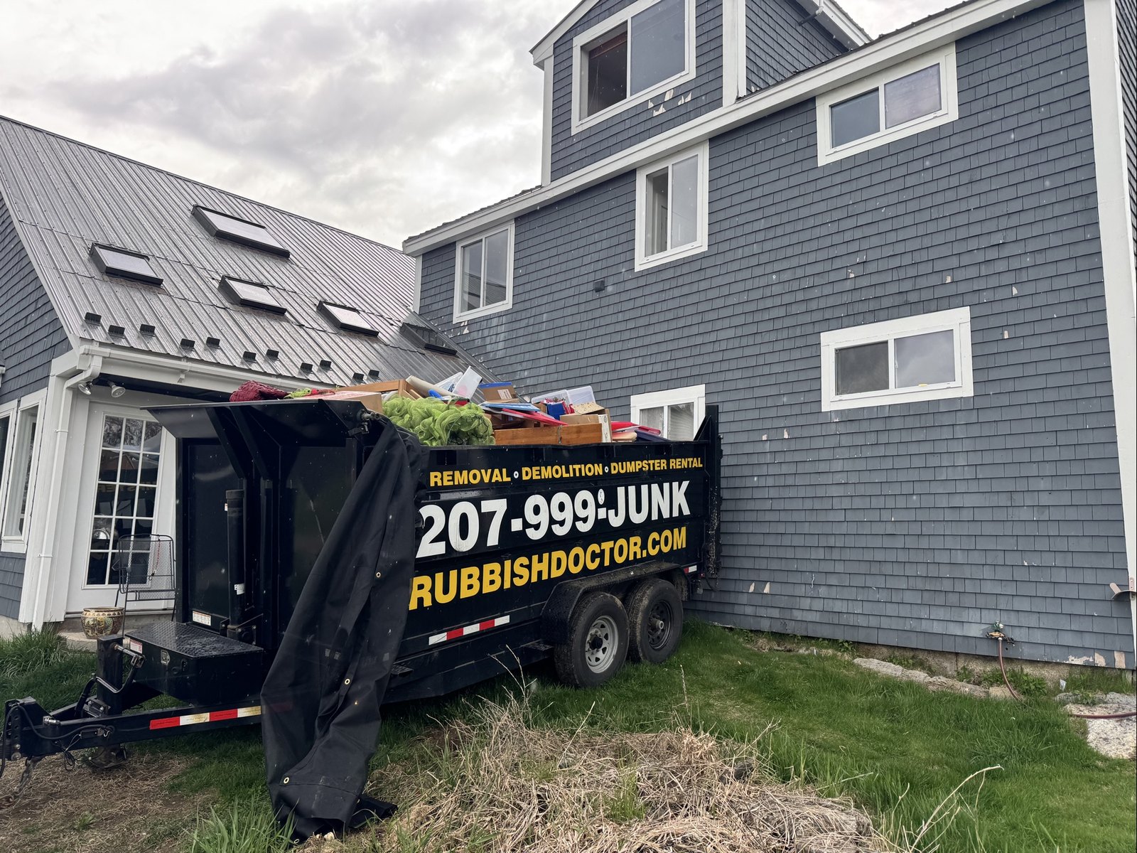 A Rubbish Doctor dumpster trailer parked in a residential driveway